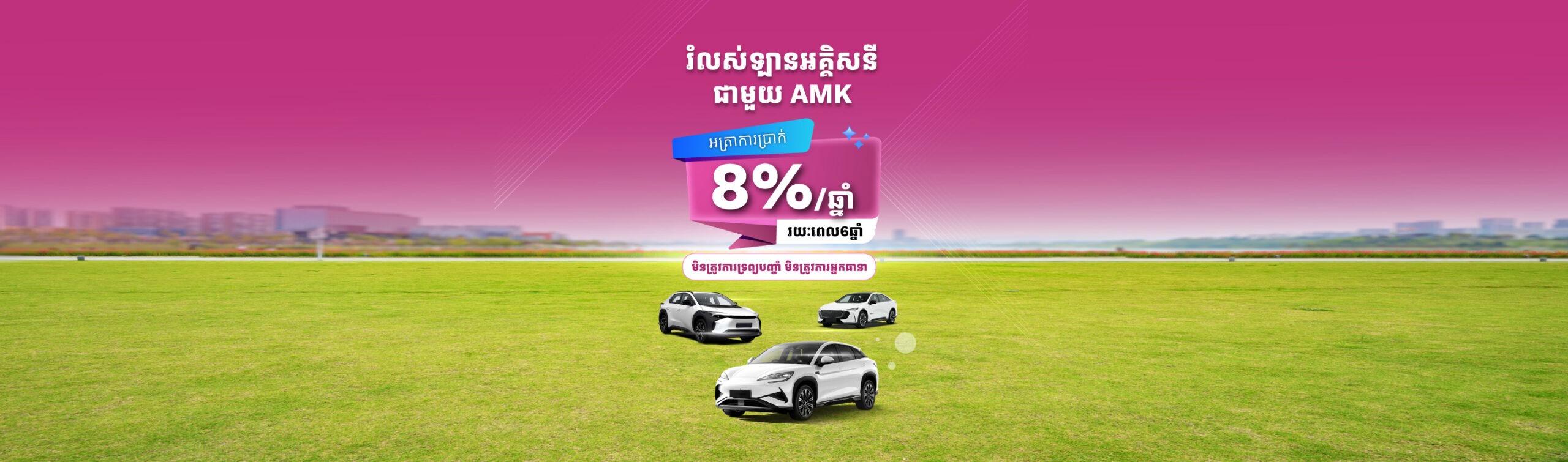 Promotional banner in Khmer advertising an 8% loan offer, showing three white cars on a green field under a pink gradient sky.